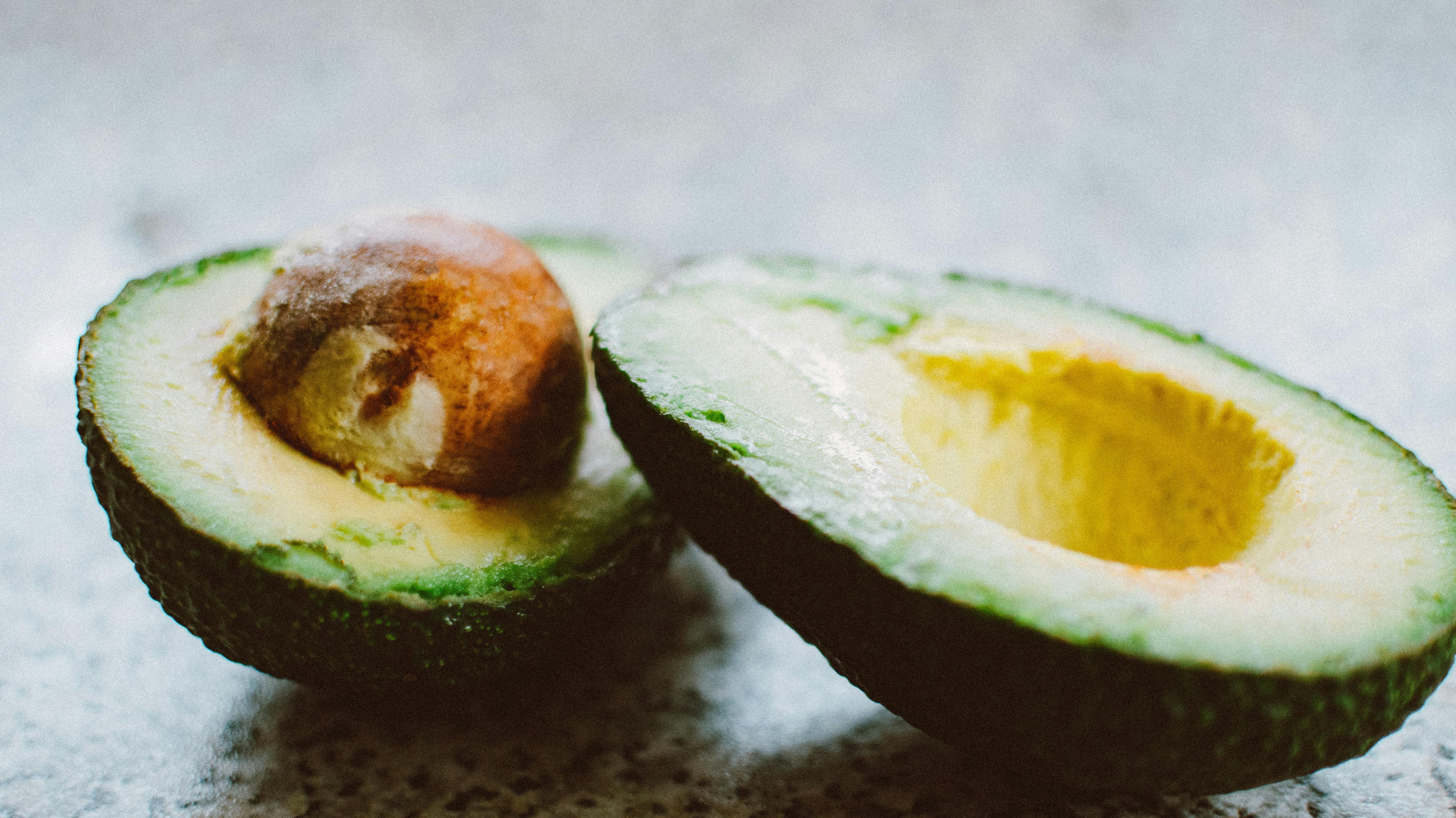 A cut avocado on a table with the pit inside