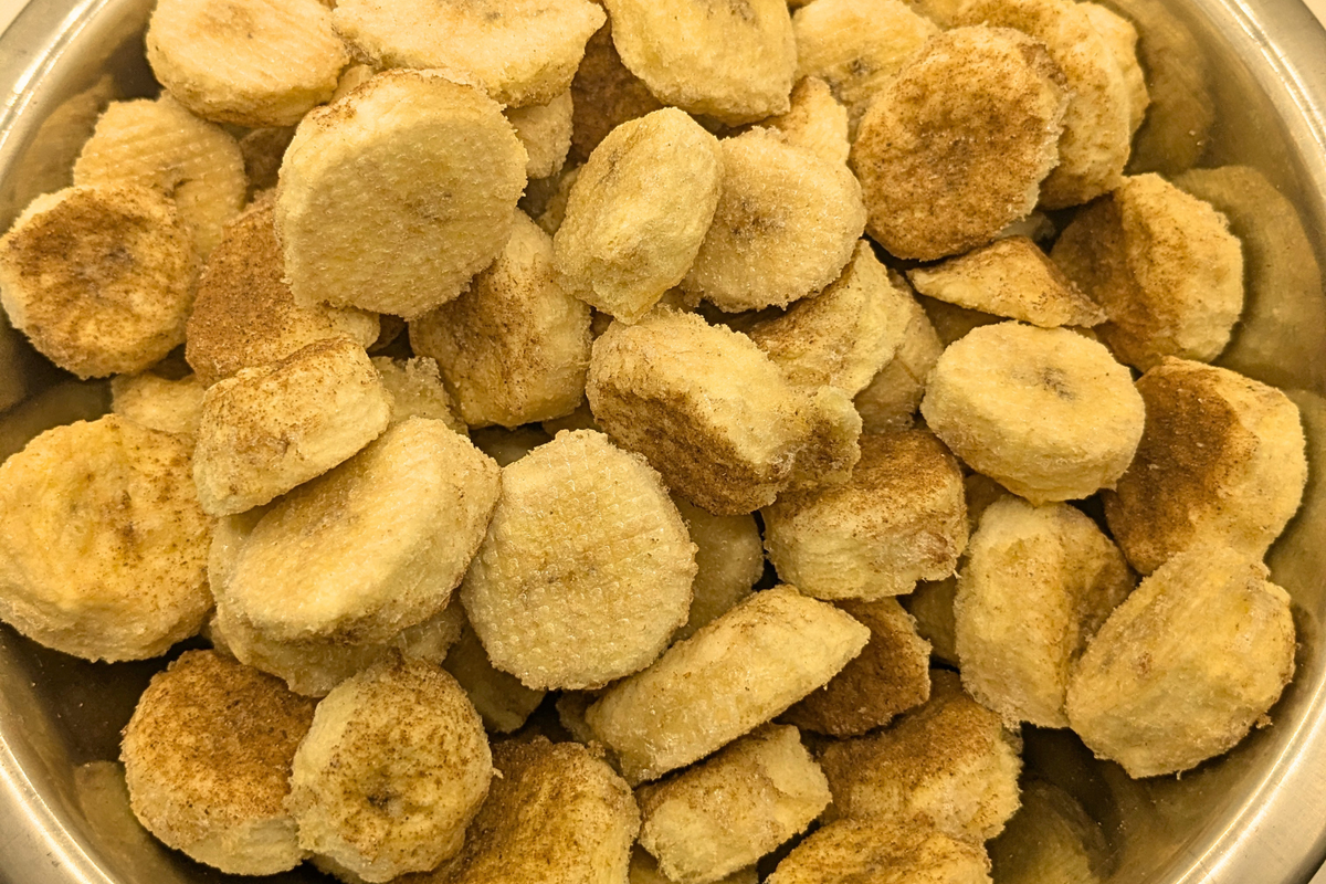 Freeze dried honey cinnamon bananas in a metal bowl on a white background