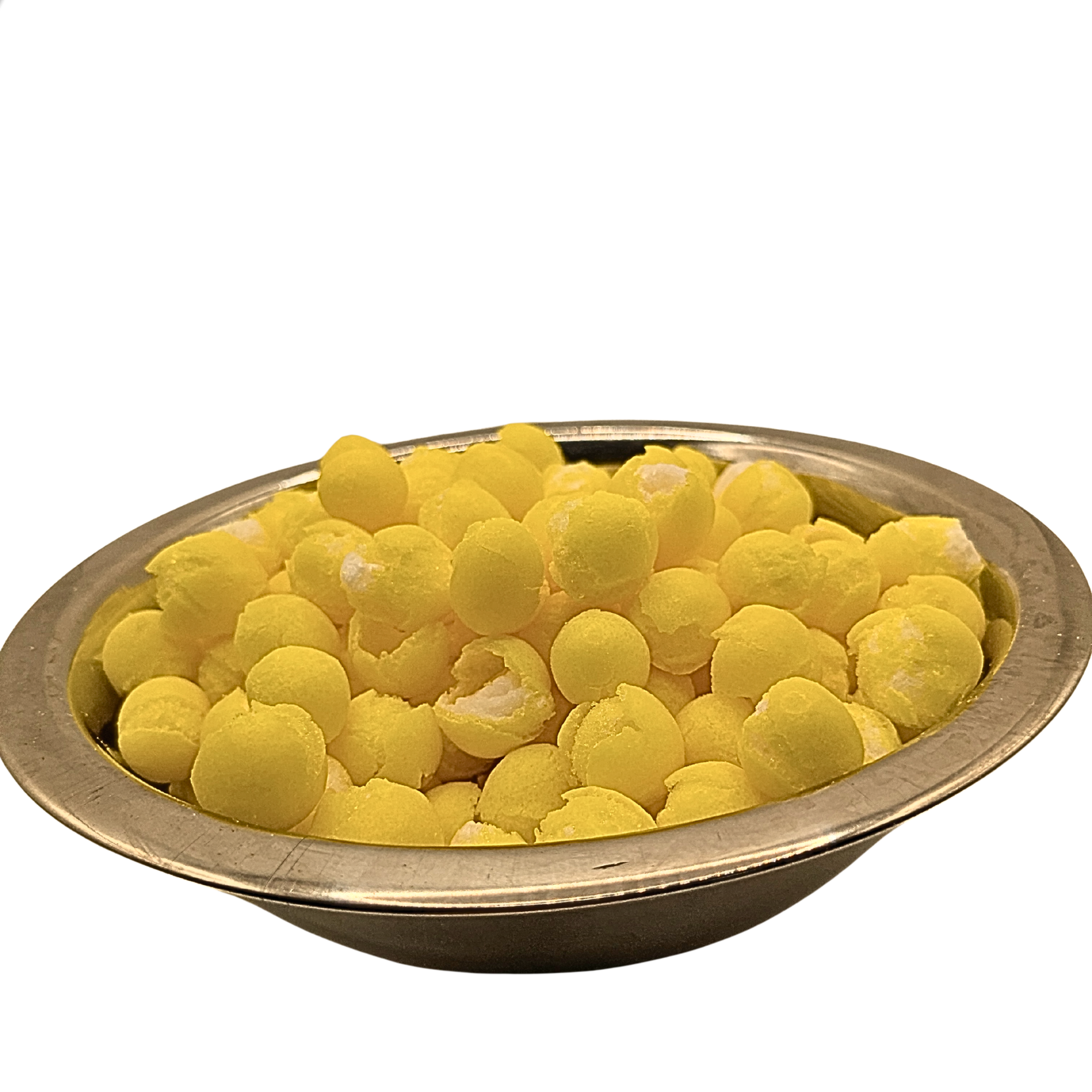 Yellow spherical freeze dried lemon candy piled in a round metallic bowl on a white background.