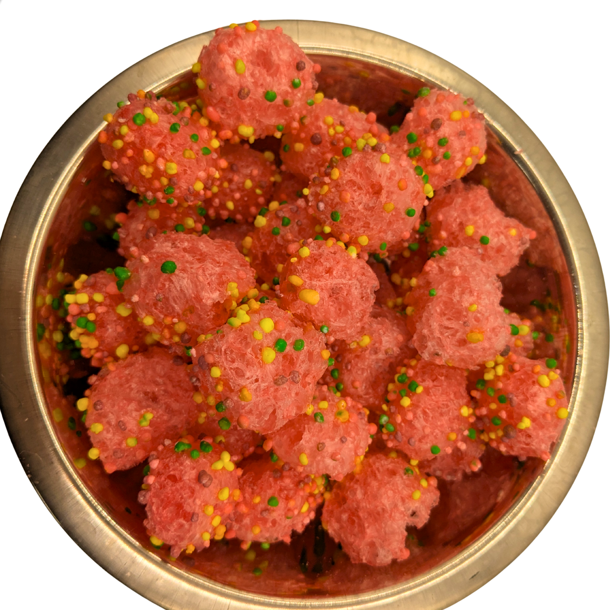 A top-down view of pink, crispy freeze dried candy coated with colorful sprinkles, served in a round metallic bowl against a white background.