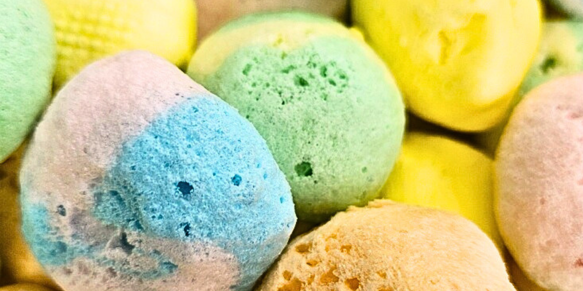 Assorted freeze dried taffy, which is fluffy and includes blue, orange, green, and yellow colored taffy