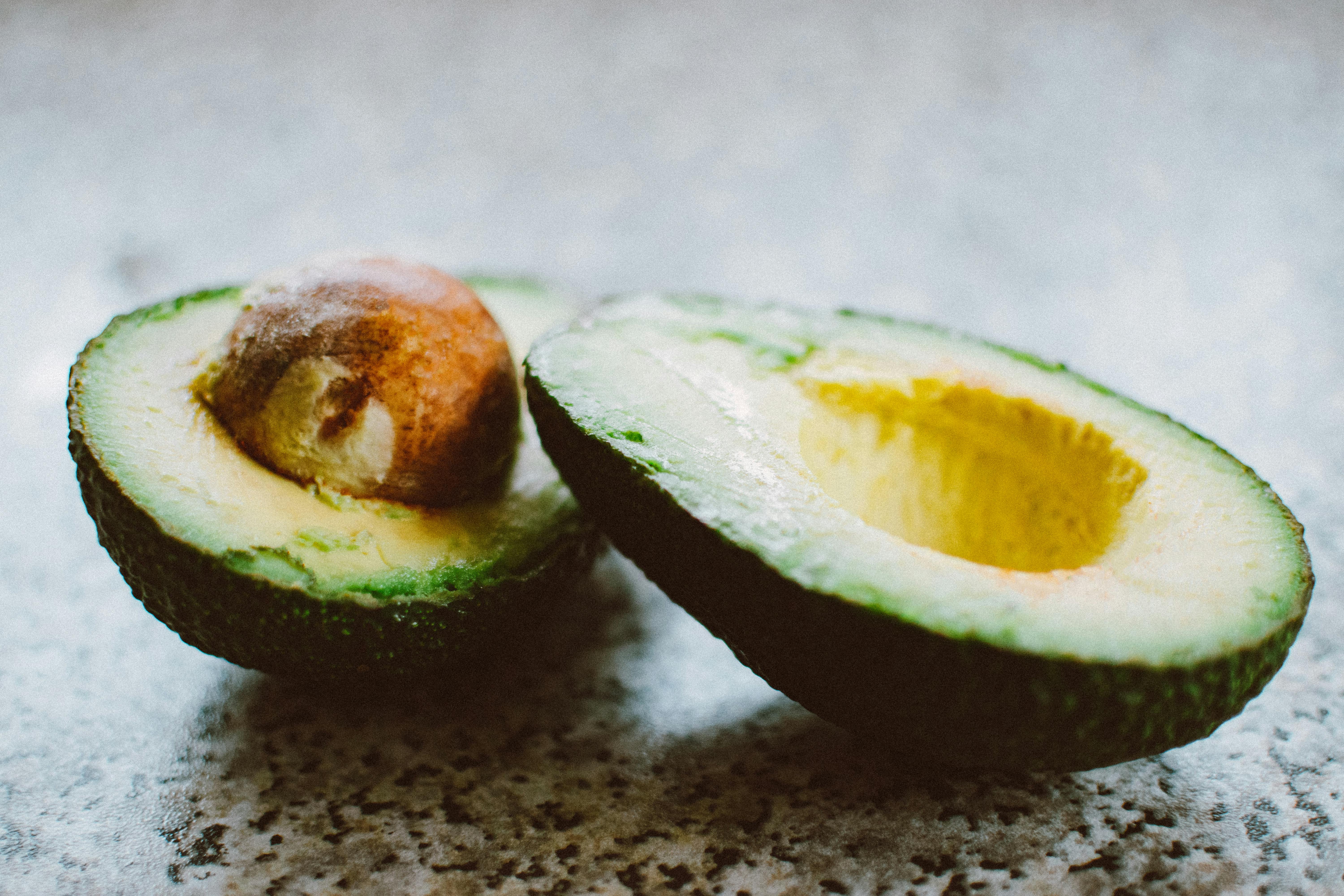 A cut avocado on a table with the pit inside