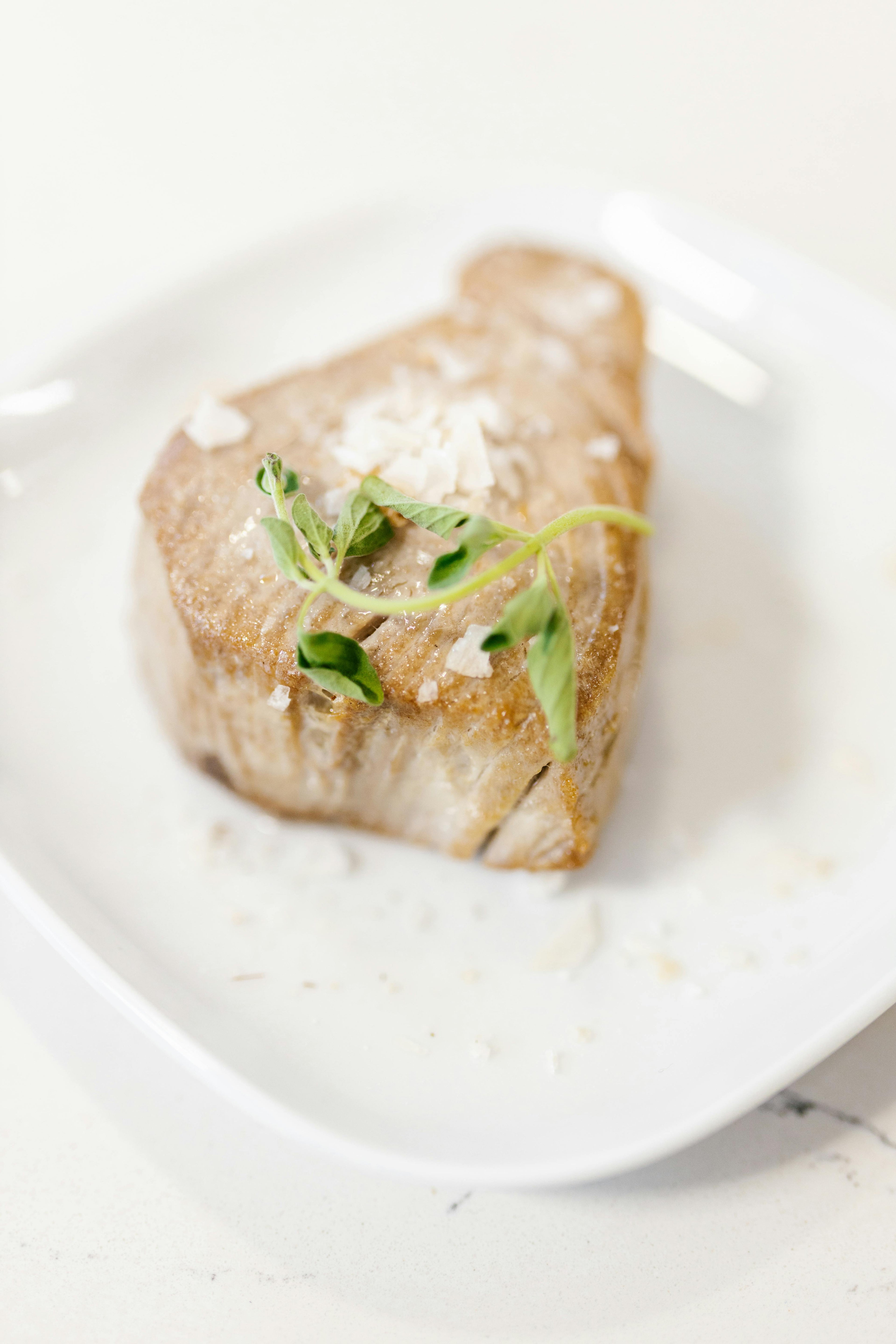 Seafood on a plate with a small garnish of green microgreens