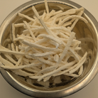 Freeze dried jicama in a metal bowl on a white background