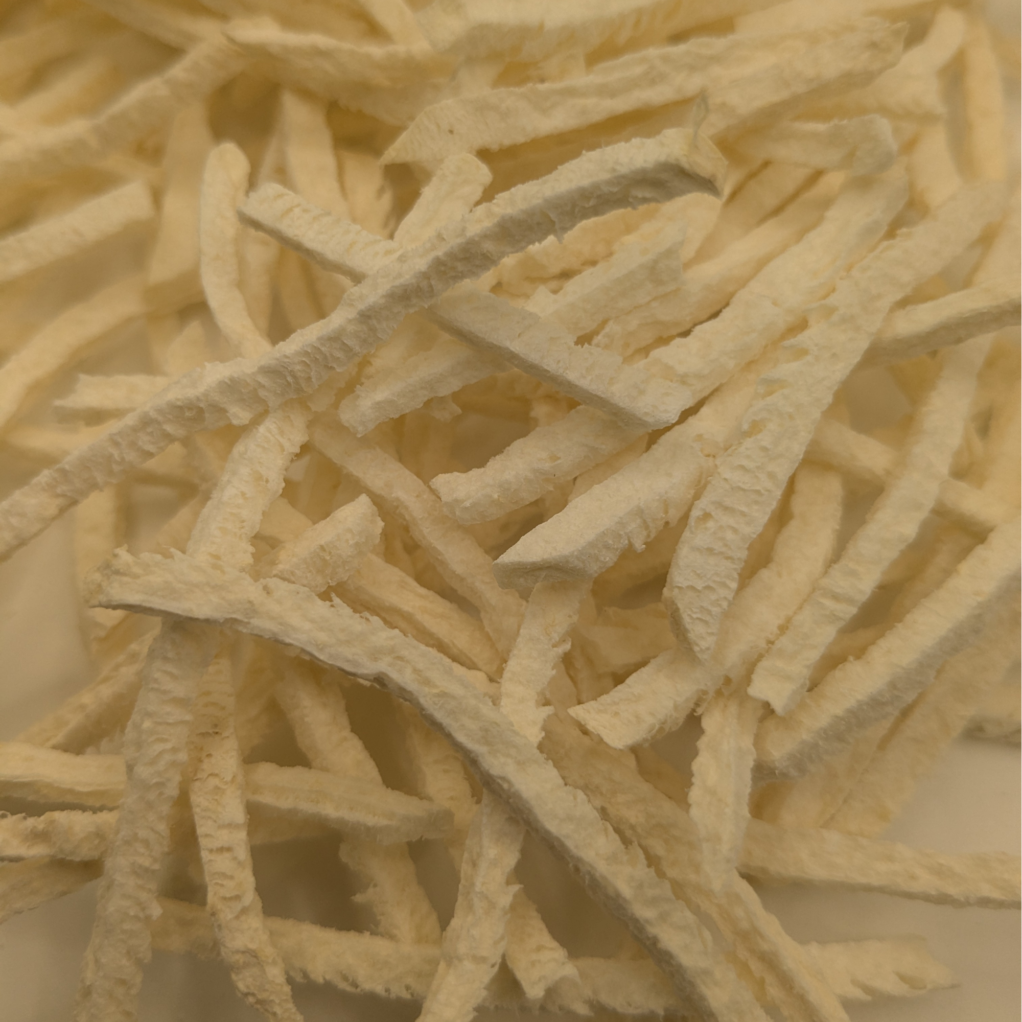 Close up of freeze dried Jicma, which are long, light, and crispy, almost cut like a french fry 