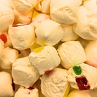 A freeze dried jujube nougat, which is white with bits of differently colored jelly inside