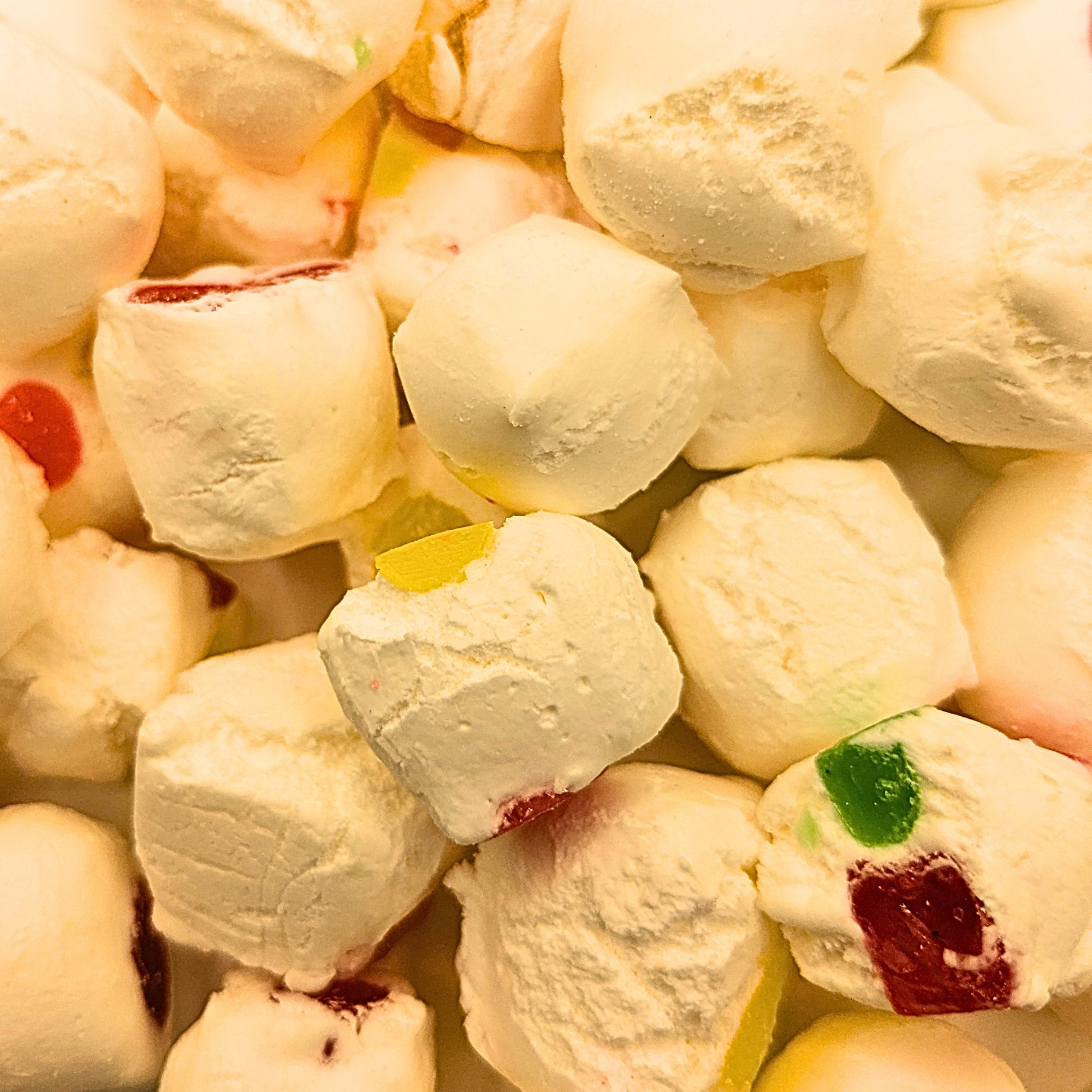 A freeze dried jujube nougat, which is white with bits of differently colored jelly inside
