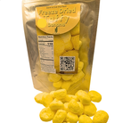 A bag of freeze dried banana taffy with a pile of taffy in front of it