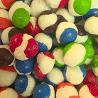 Freeze dried candy, which is white in the center like its burst with a colorful outer shell in red, green, pink, and black.