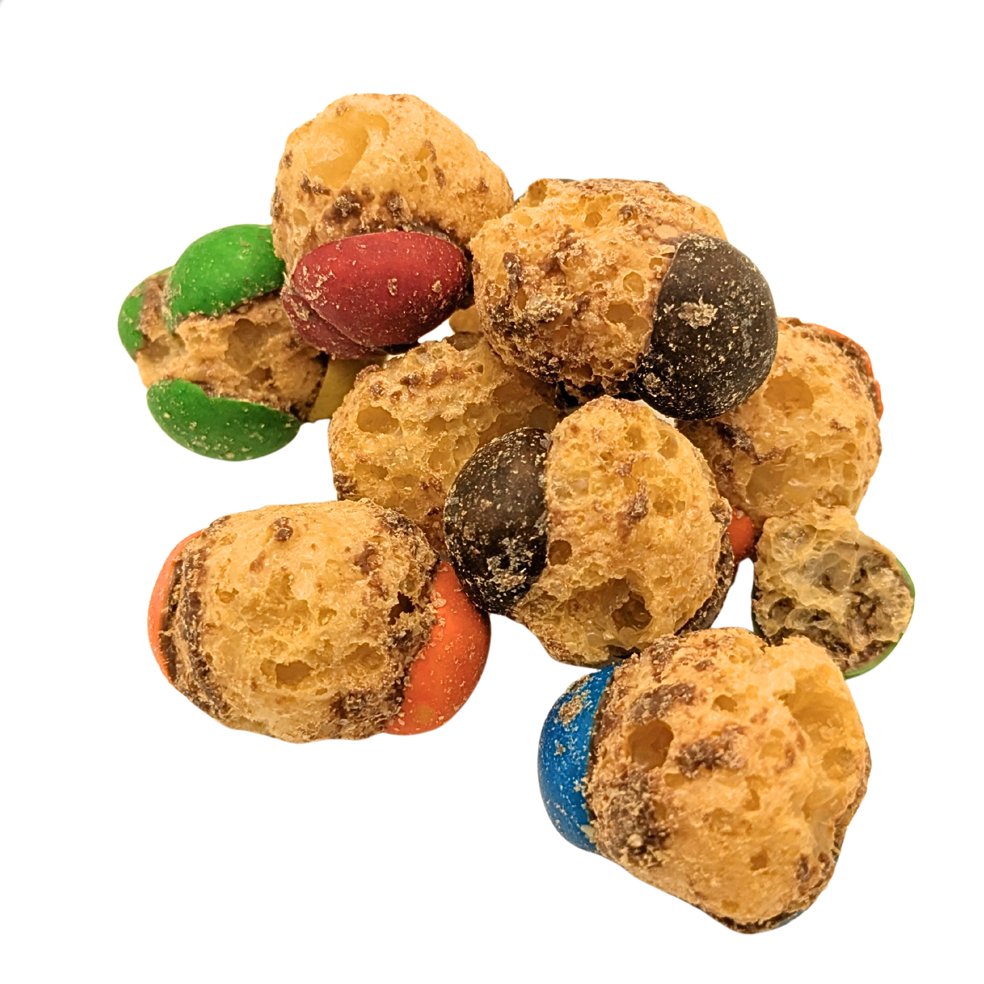 Freeze dried caramel and chocolate candy with green, red, brown, and blue shells piled on a white background