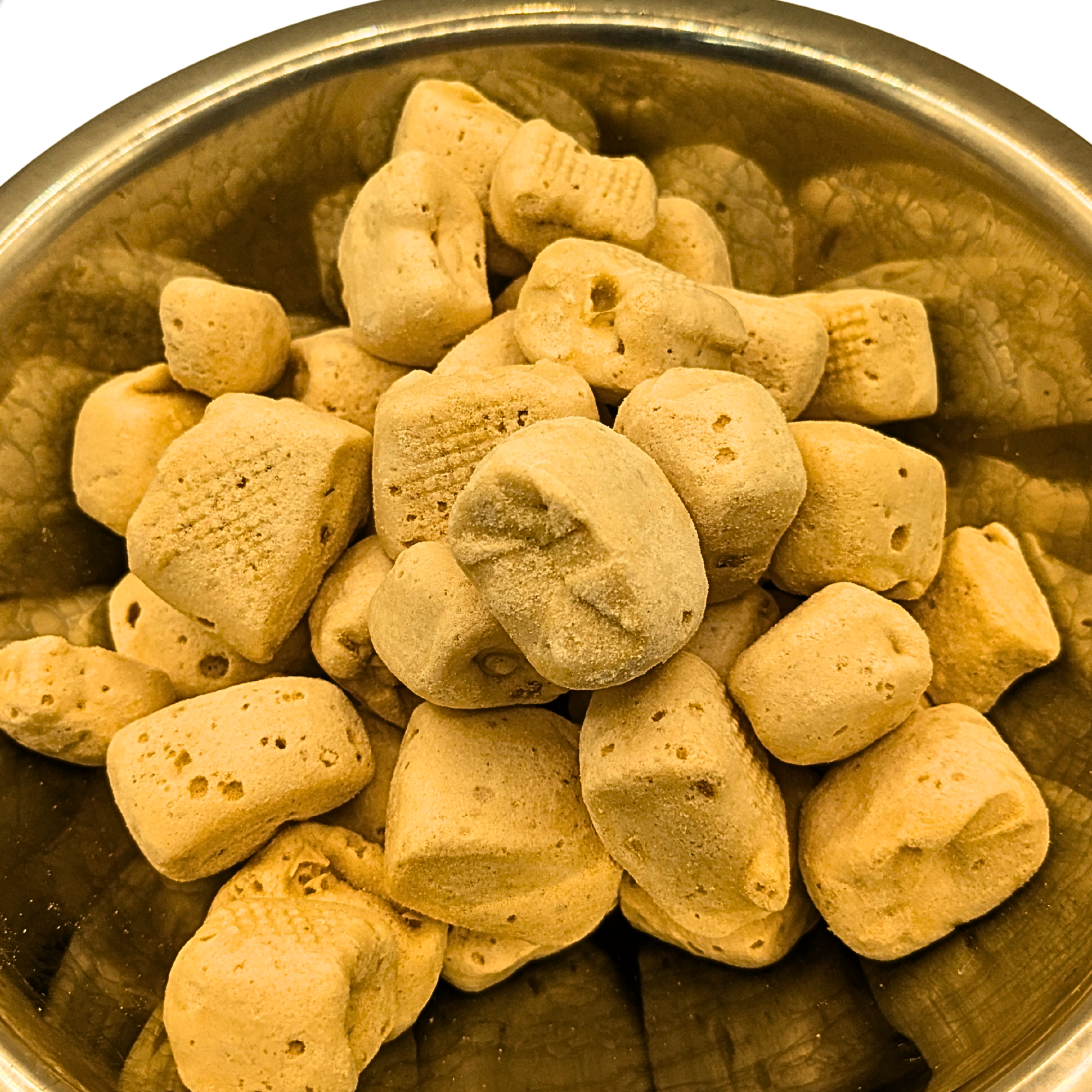 Freeze dried honey candy in a metal bowl on a white background