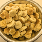 Freeze dried honey cinnamon bananas in a metal bowl on a white background