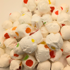 Freeze dried jujube nougats, which are white with a marshmallow texture with red, green, yellow, and orange bits of jelly