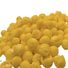 A pile of freeze dried lemon candy on a plain white background.