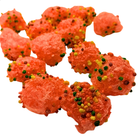 Several pieces of bright orange-red candy sprinkled with multicolored sprinkles, arranged on a plain white background.