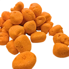 A pile of small, textured orange freeze dried taffy on a solid white background.