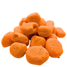 A pile of textured orange freeze dried taffy on a plain white background.