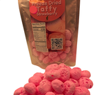 Package of Freeze Dried Strawberry Taffy with a pile of freeze dried taffy in front on a white background