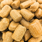 A close-up pile of Tootsy Bitz, which are cylindrical chocolate candy 