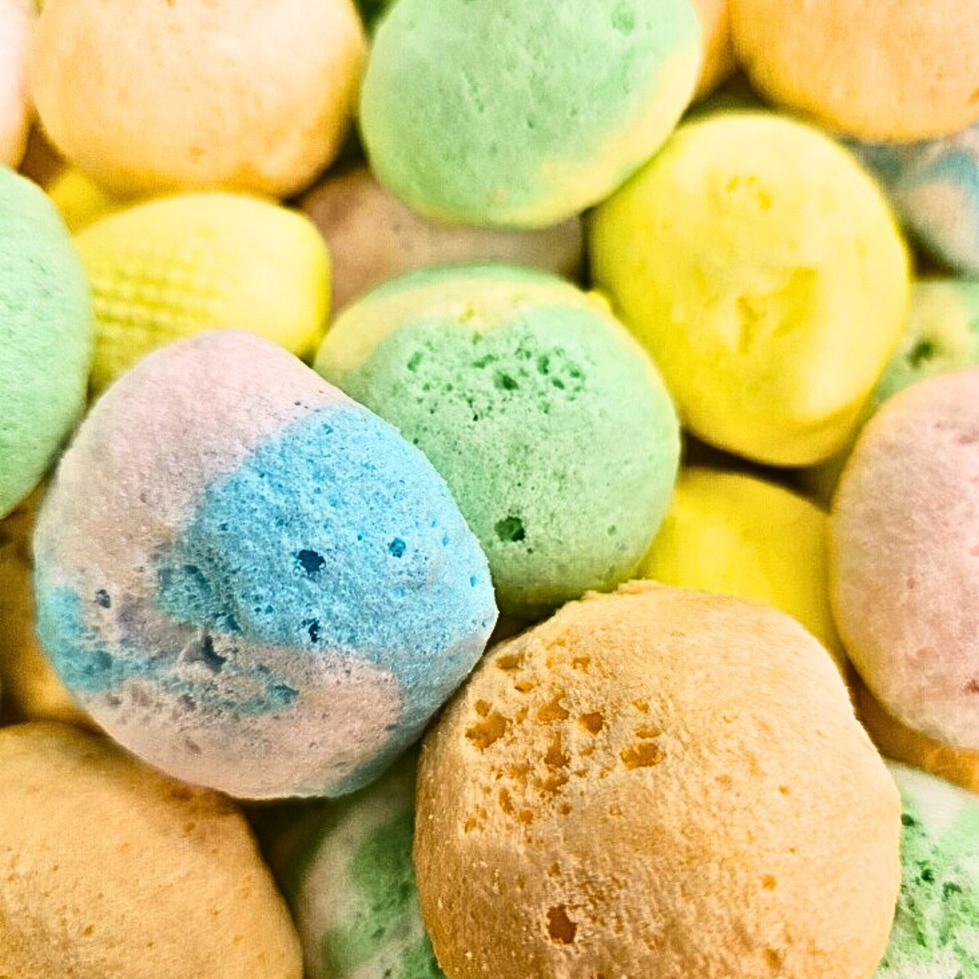 Assorted freeze dried taffy, which is fluffy and includes blue, orange, green, and yellow colored taffy