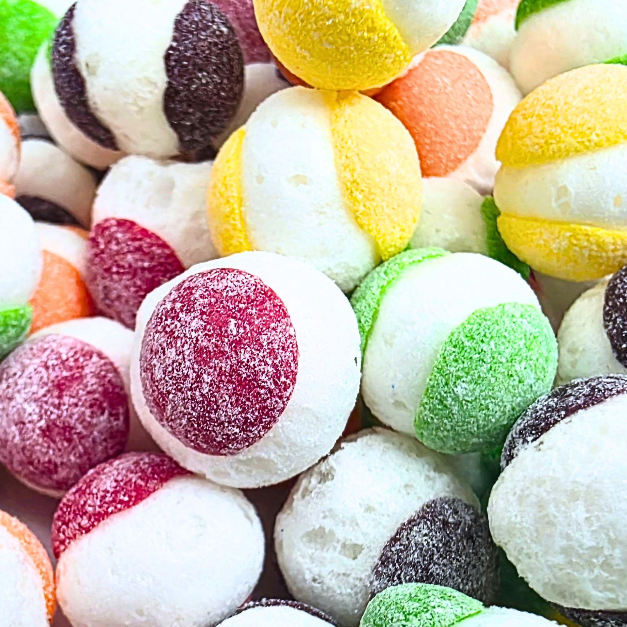 Freeze dried sour candy, which has a bursting white in the middle, and colors including red, green, yellow, and purple that resemble freeze dried Skittles